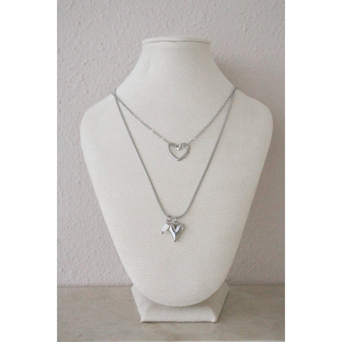Detail van hartjes collier met glanzende stainless steel hanger en schelp hartje