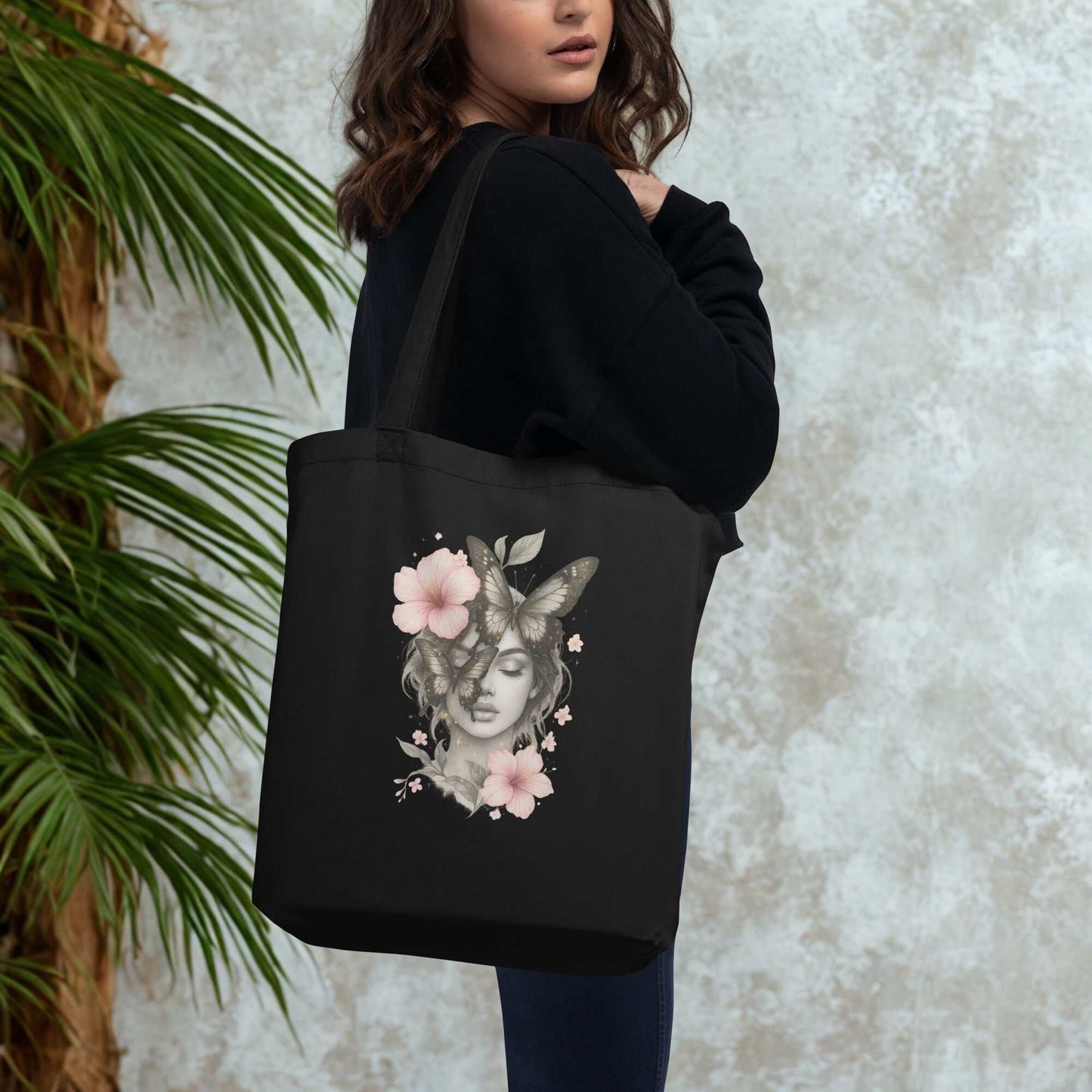 Black Eco Tote Bag with a floral and butterfly design, carried by a woman, eco-friendly and spacious reusable shopping bag