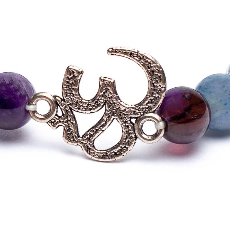 Close-up van Amethist Mala armband met Ohm symbool en edelstenen van amethist, blauwe aventurijn en bergkristal