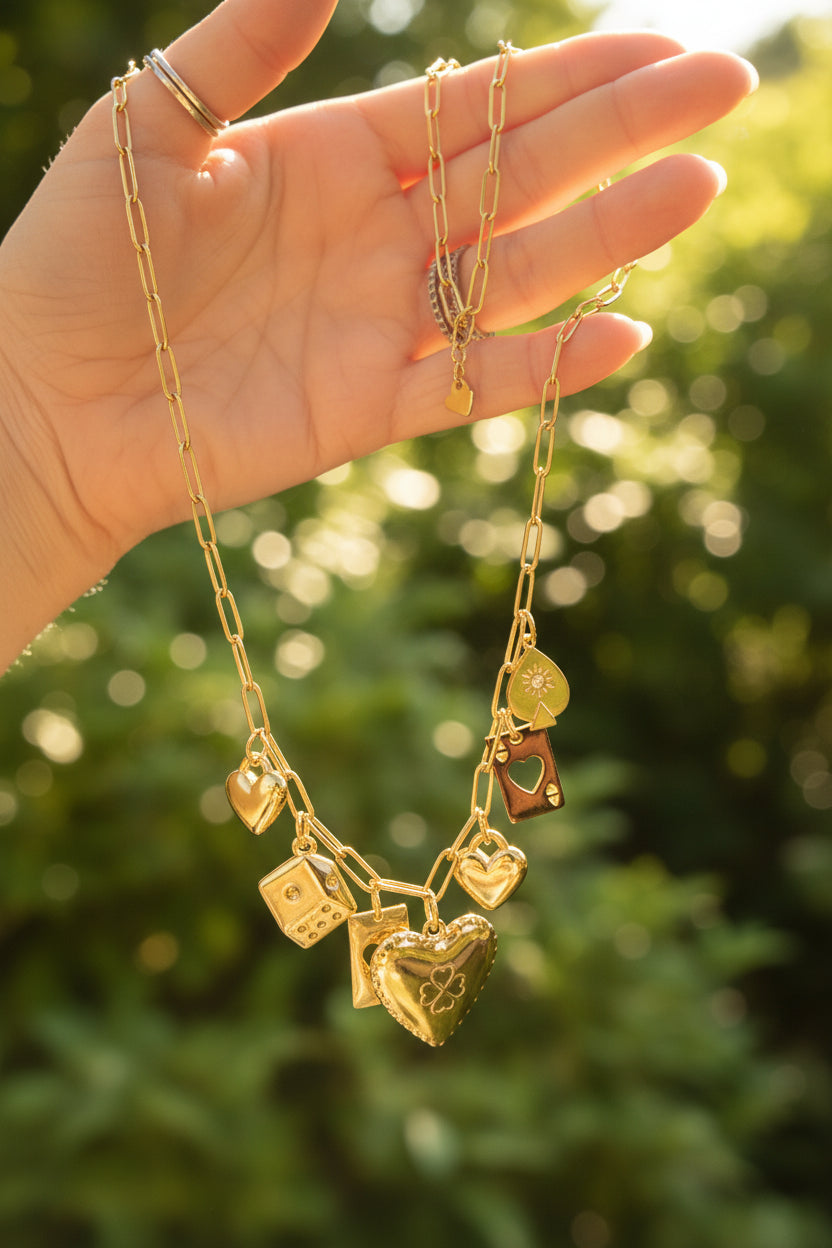 Luxe goudkleurige waterproof RVS bedelketting sfeervol vastgehouden in een hand in de natuur, glanzend in de warme zonnestralen.