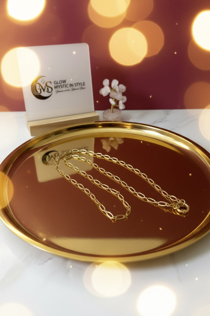 Tijdloze gouden damesketting van roestvrij staal voor dagelijks gebruik gepresenteerd op een marmerkleurige schaal met display van Glow Mystic in Style