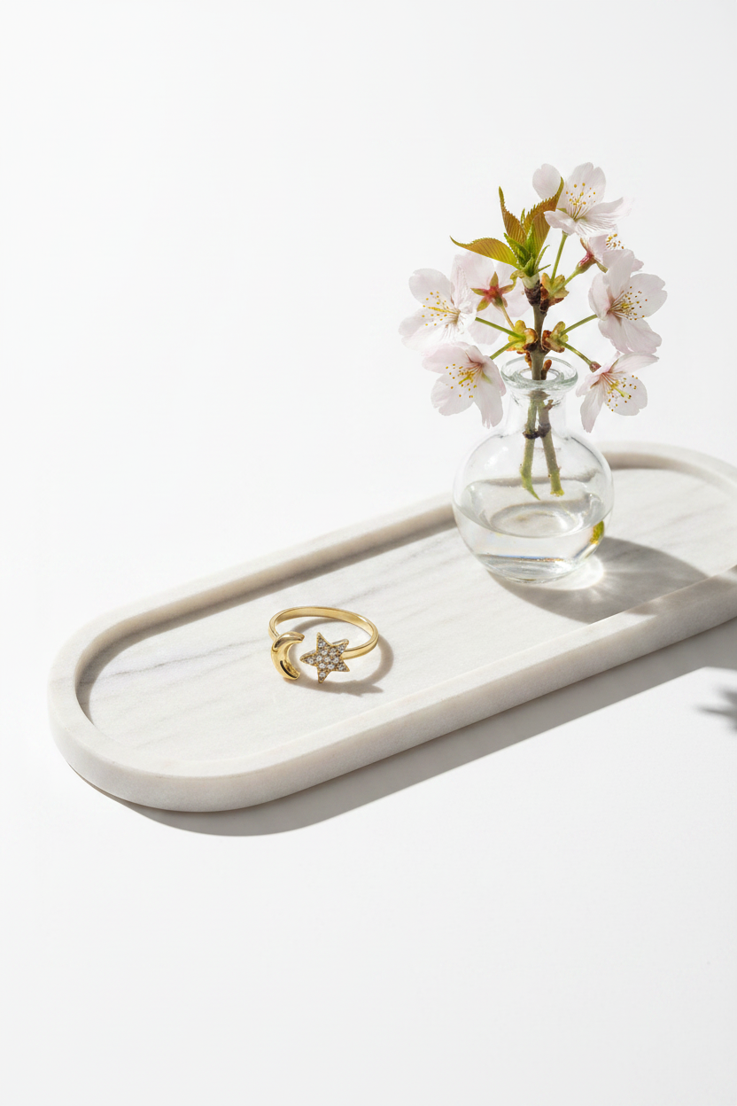 Sfeerbeeld van een langwerpige marmeren schaal met een ring en een vaasje bloemen