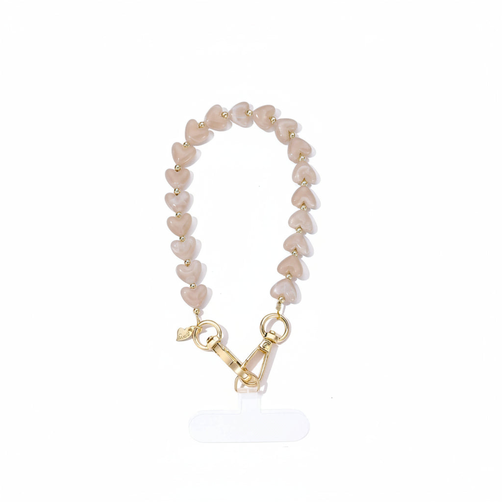 Luxe soft mocha telefoonkoord gemaakt van glanzende parelmoer hartjeskralen en goudkleurige details met een hartjesbedel van Glow Mystic in Style.t 