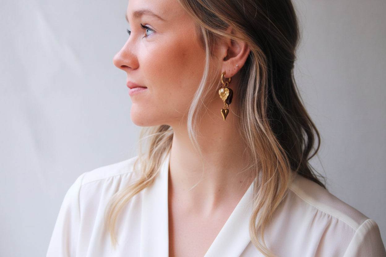 Goudkleurige RVS oorbellen met hartbedels en amberkleurige nugget statement hoops