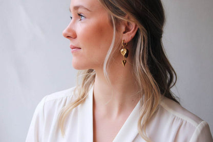 Goudkleurige RVS oorbellen met hartbedels en amberkleurige nugget statement hoops