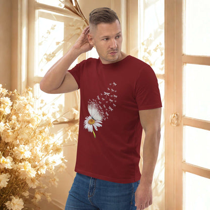 Man wearing a red Bloom & Fly Mystic Daisy Organic Cotton Tee with a daisy design and flying birds, paired with blue jeans in a bright room