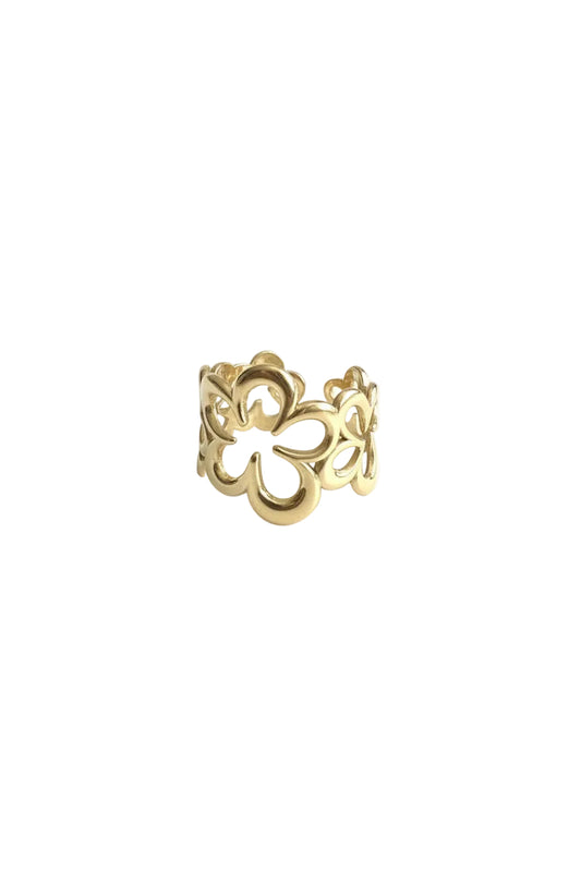 Een opvallende goudkleurige stainless steel statement ring met een uniek, opengewerkt bloemen- of klaver-motief, neutraal gefotografeerd op een clean witte achtergrond.