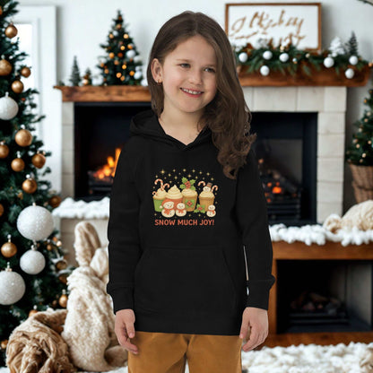 child wearing black Kids Christmas Hoodie with festive cupcake design standing by decorated Christmas tree and fireplace