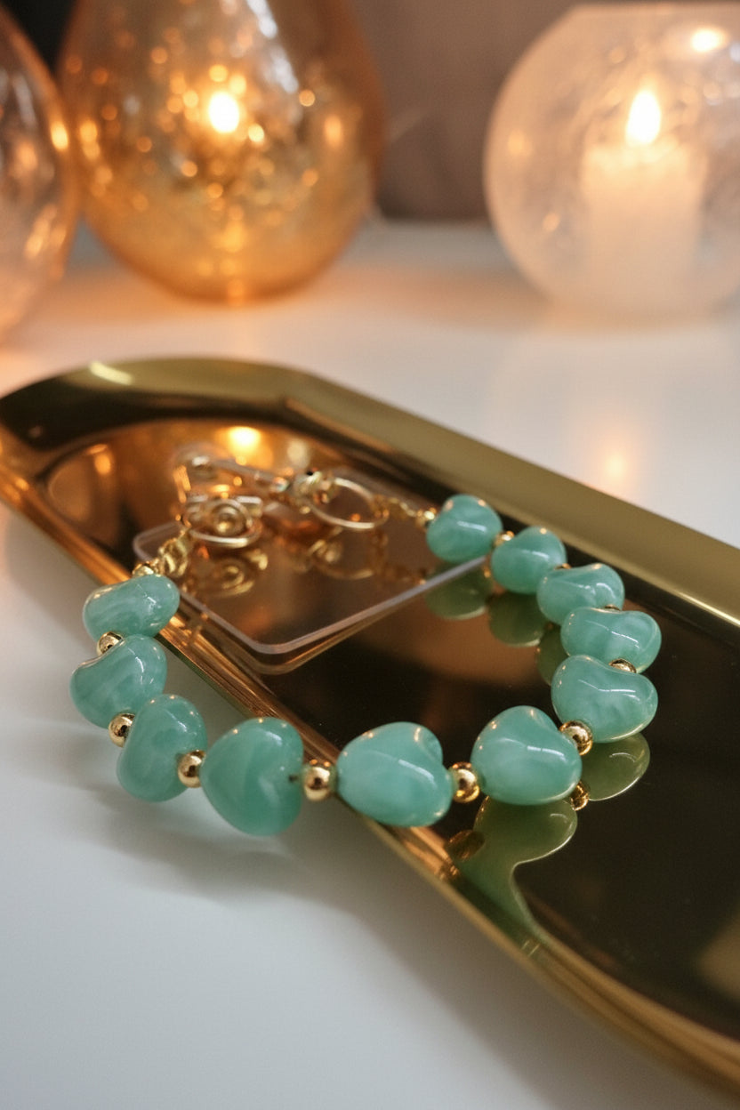 Kralen telefoonkoord  close up met lichtgroene harten op een gouden schaal 