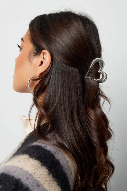 Zilveren metalen hart haarclip gedragen in half-opgestoken bruin haar