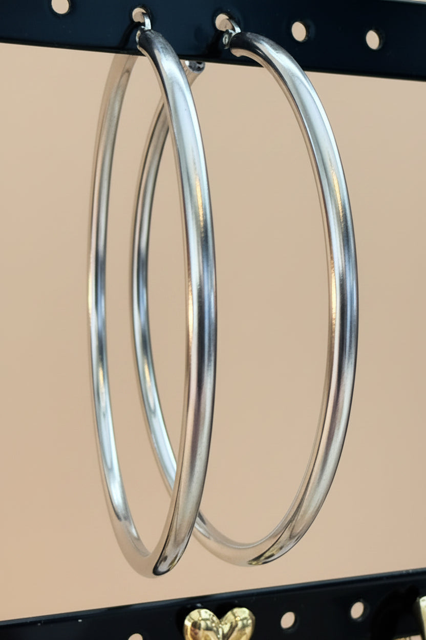 Close-up van Glow Mystic in Style zilveren basic hoop oorbellen aan een sieradenrekje