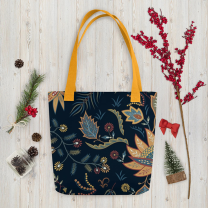 Autumn Floral Tote Bag with dark background and colorful fall leaves design with mustard yellow handles on wooden surface with seasonal decorations