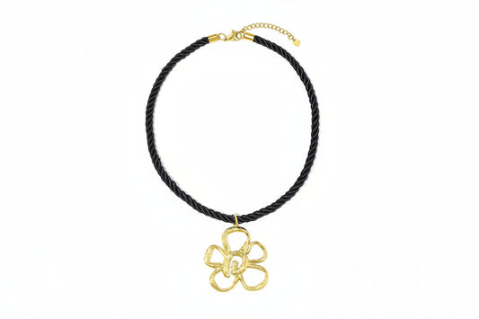 Zwarte koordketting met grote gouden bloemhanger.