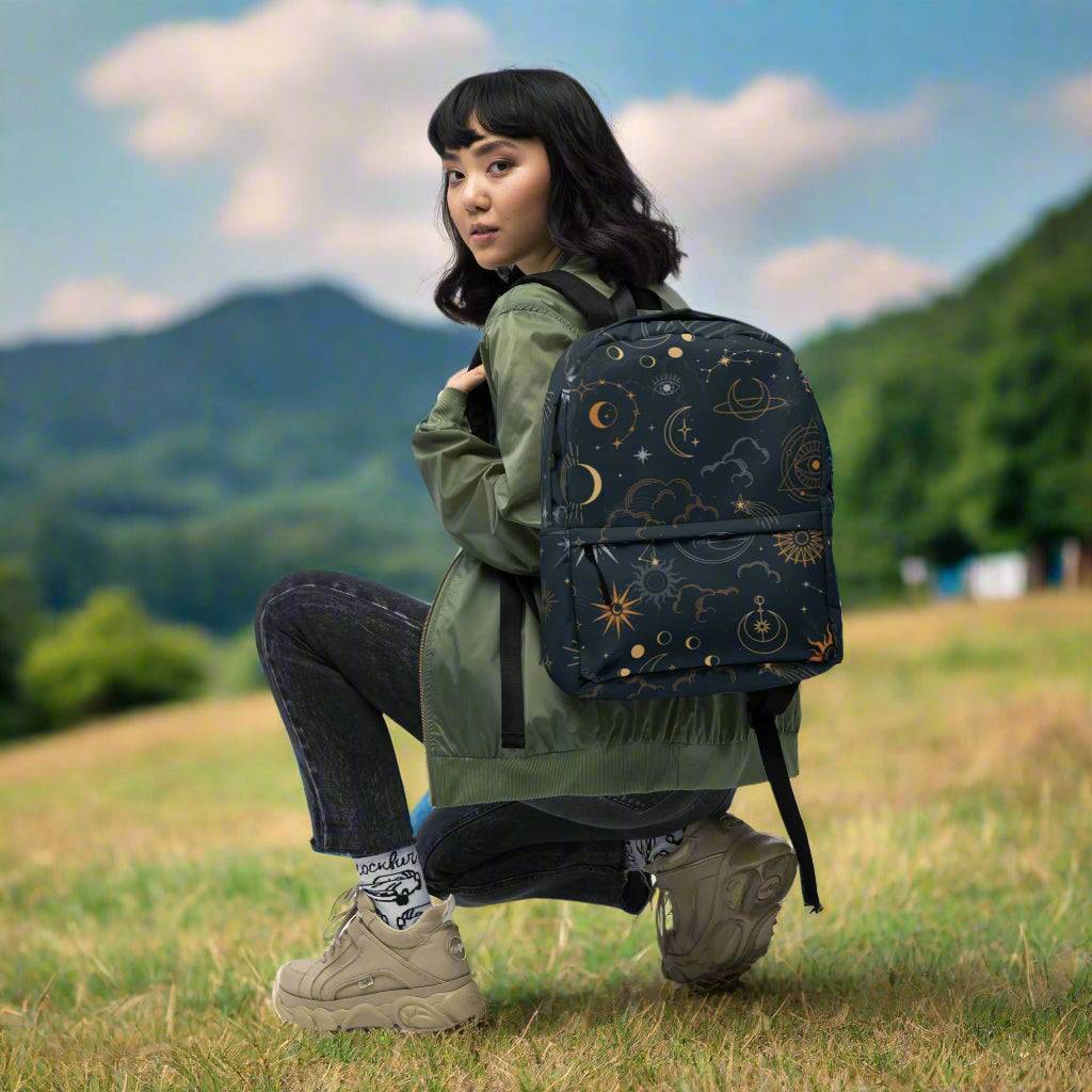 Mystic Moons and Stars Backpack with celestial moons and stars design worn by woman outdoors with mountains in background
