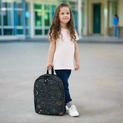 Child standing holding Mystic Moons and Stars Backpack with celestial design featuring moons and stars