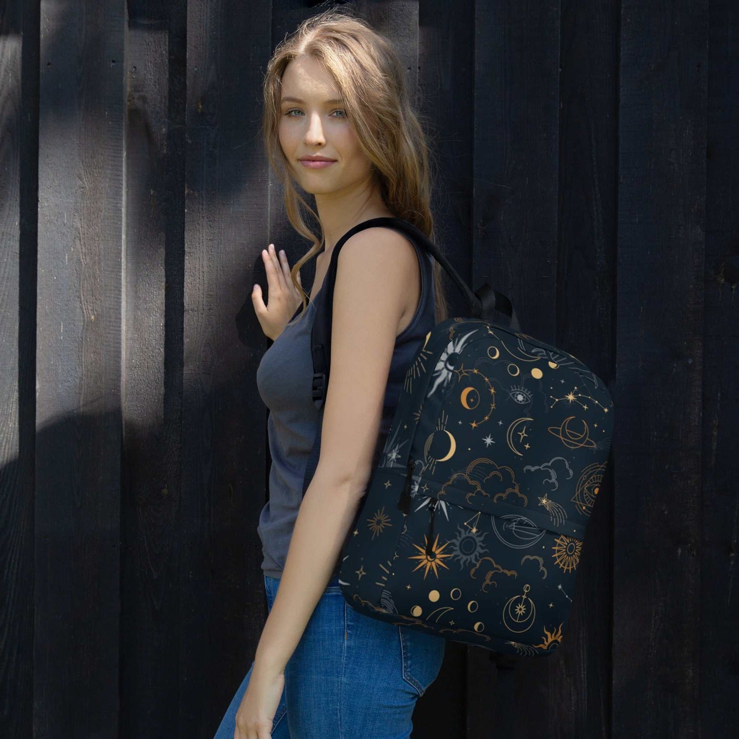Woman wearing Mystic Moons and Stars Backpack with celestial gold moon and star design on black background