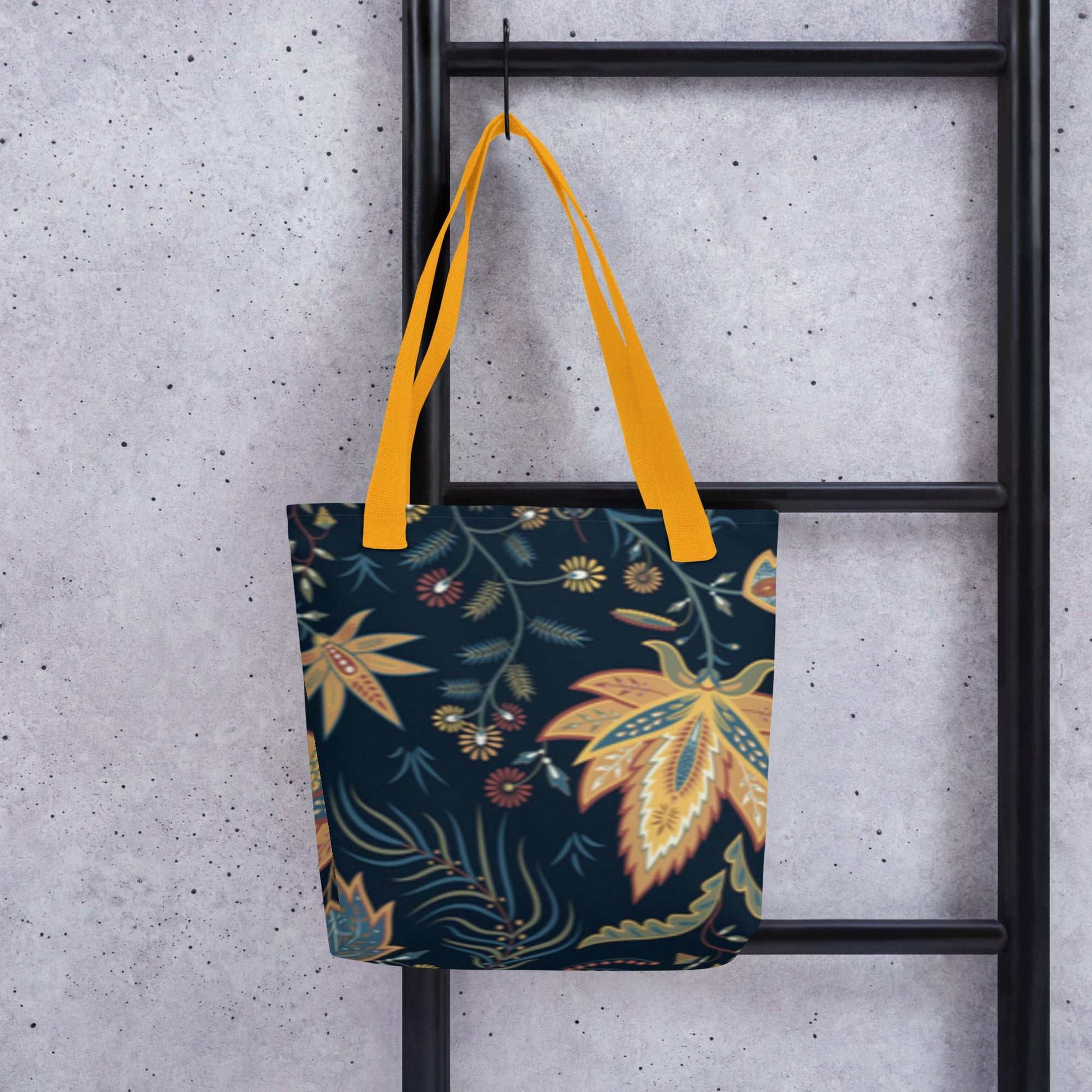 Autumn Floral Tote Bag with yellow handles and dark floral pattern hanging on black ladder against concrete wall