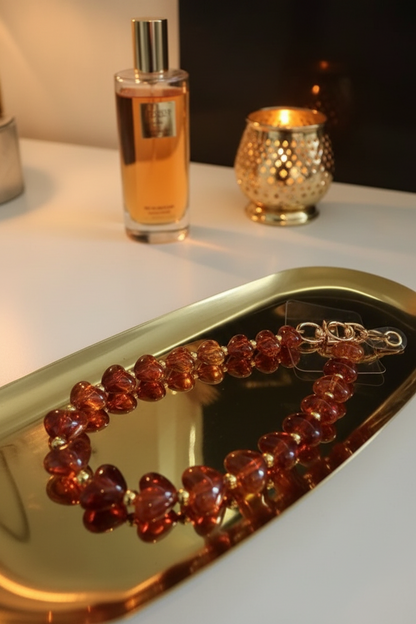 Glow Mystic n Style amberkleurige hartjes koord op goudkleurig schaaltje op een lifestyle achtergrond.