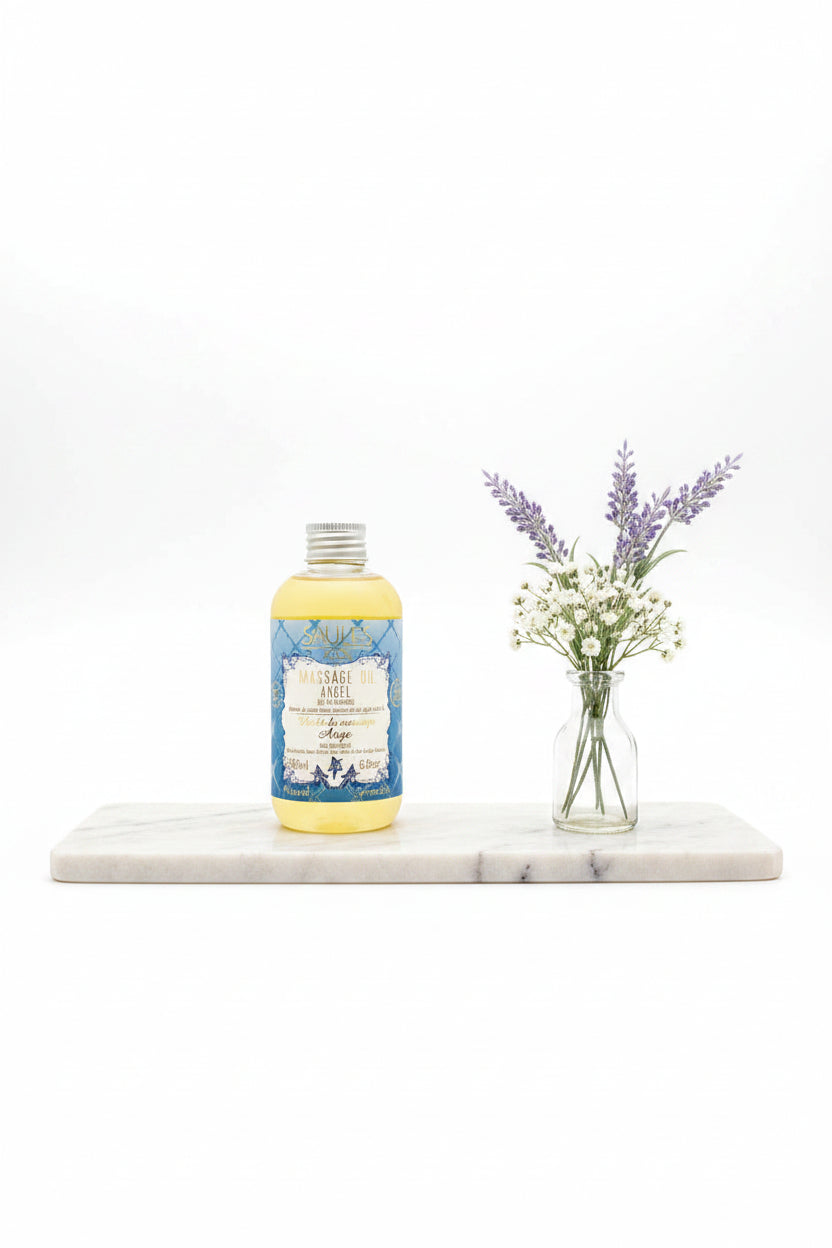 Saules Fabrika luxe massageolie Angel 200ml doseerfles met lichtblauw label tegen een sfeervolle achtergrond met droogbloemen en pampasgras - Glow Mystic in Style.