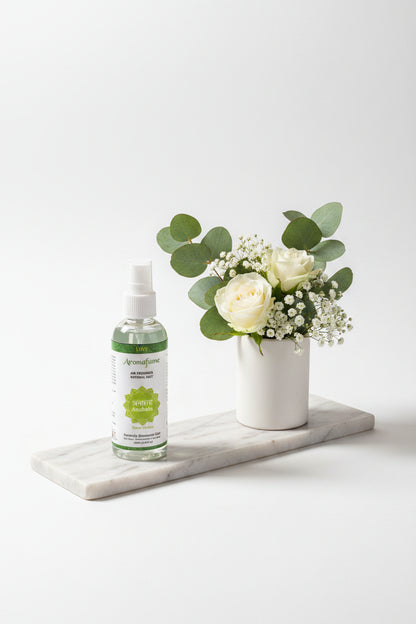 Luxe Aromafume Anahata Hartchakra spray 100ml met groen label en spiritueel symbool voor liefde en harmonie gepresenteerd op een langwerpige marmeren schaal met een vaasje met witte bloemen ernaast.