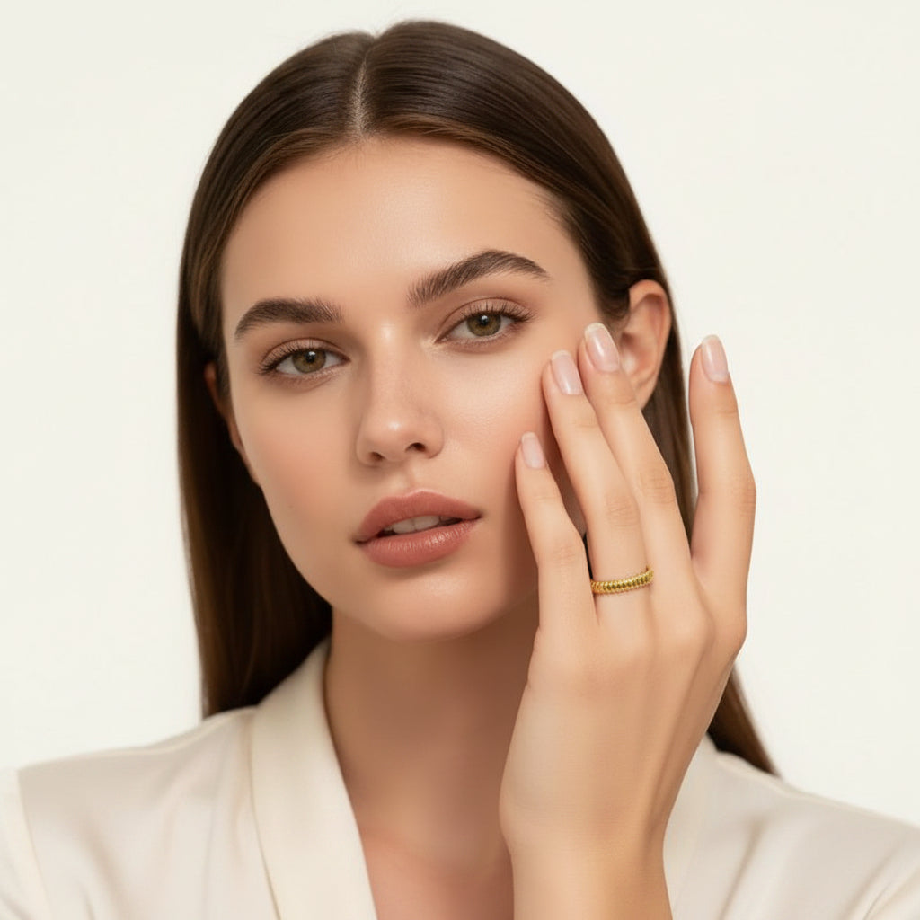 Stijlvolle goudkleurige open ring in bangle design gedragen om de vinger van een vrouw.