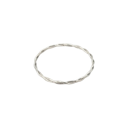 Minimalistische zilveren gedraaide bangle armband van stainless steel op een heldere witte achtergrond van Glow Mystic in Style.