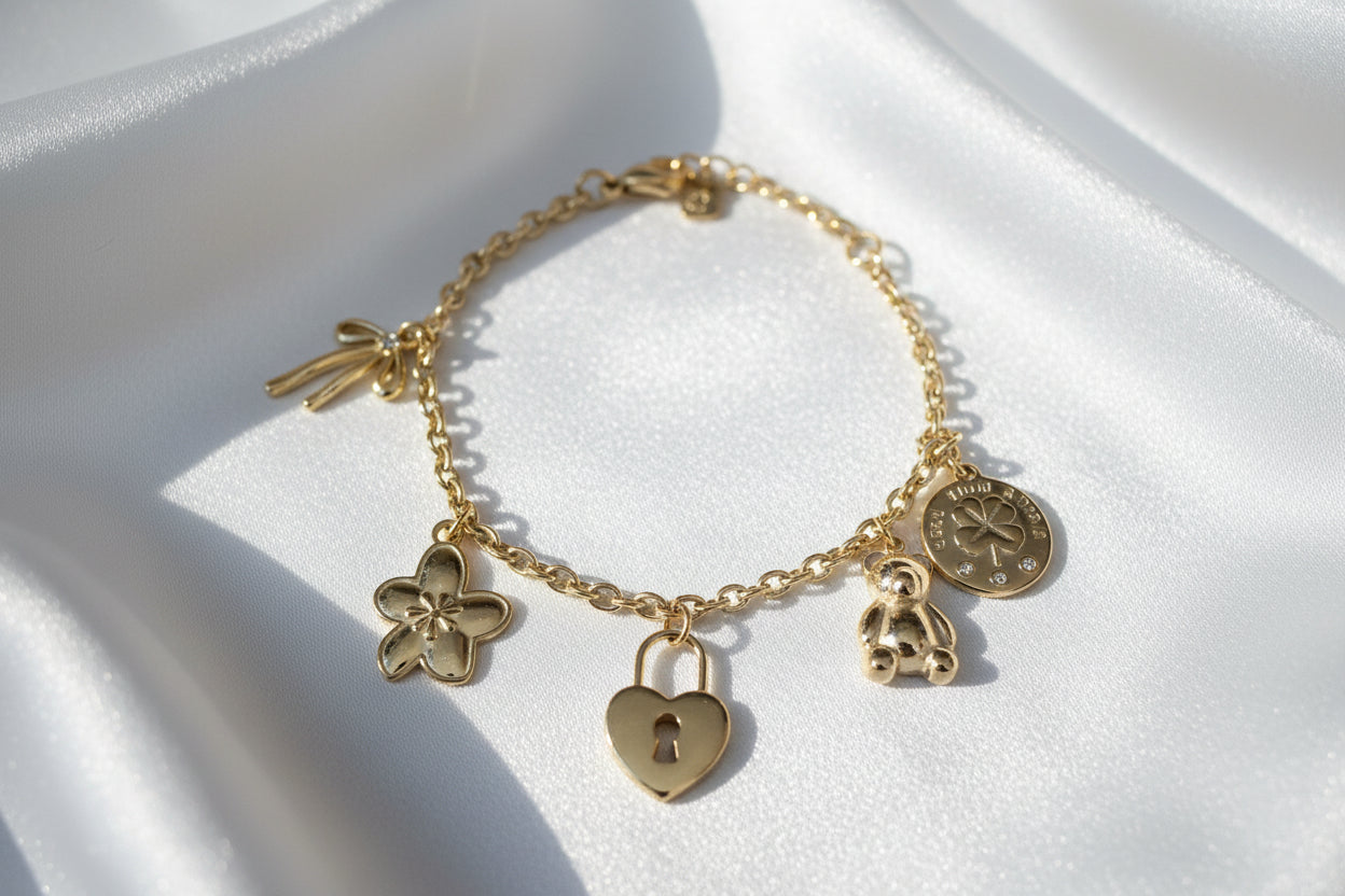 Trendy gouden bedelarmband met teddy en bloem charm