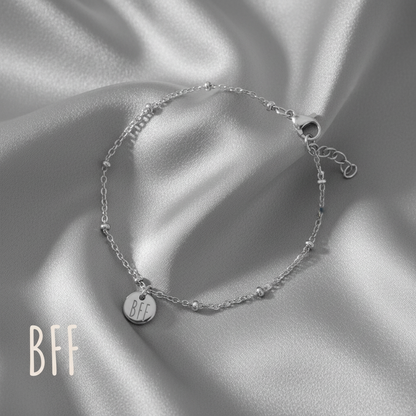 Best Friends armbandje zilver met BFF muntje op grijze satijnen achtergrond, hypoallergeen stainless steel sieraad voor dames.