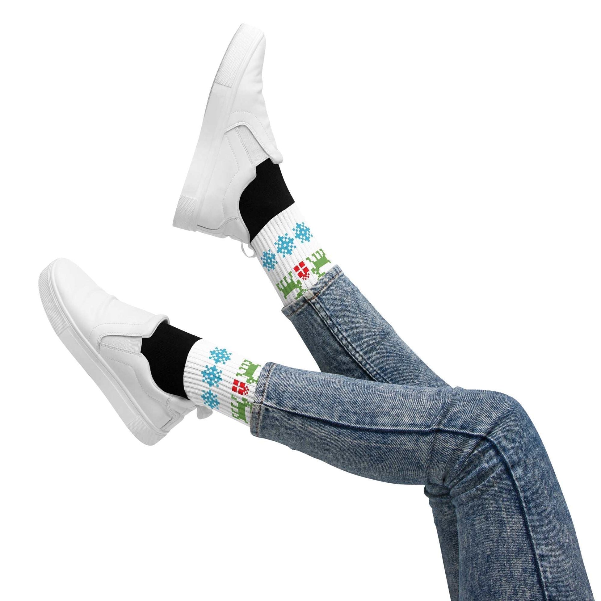 White socks with Christmas reindeer and snowflake pattern worn with white shoes and blue jeans