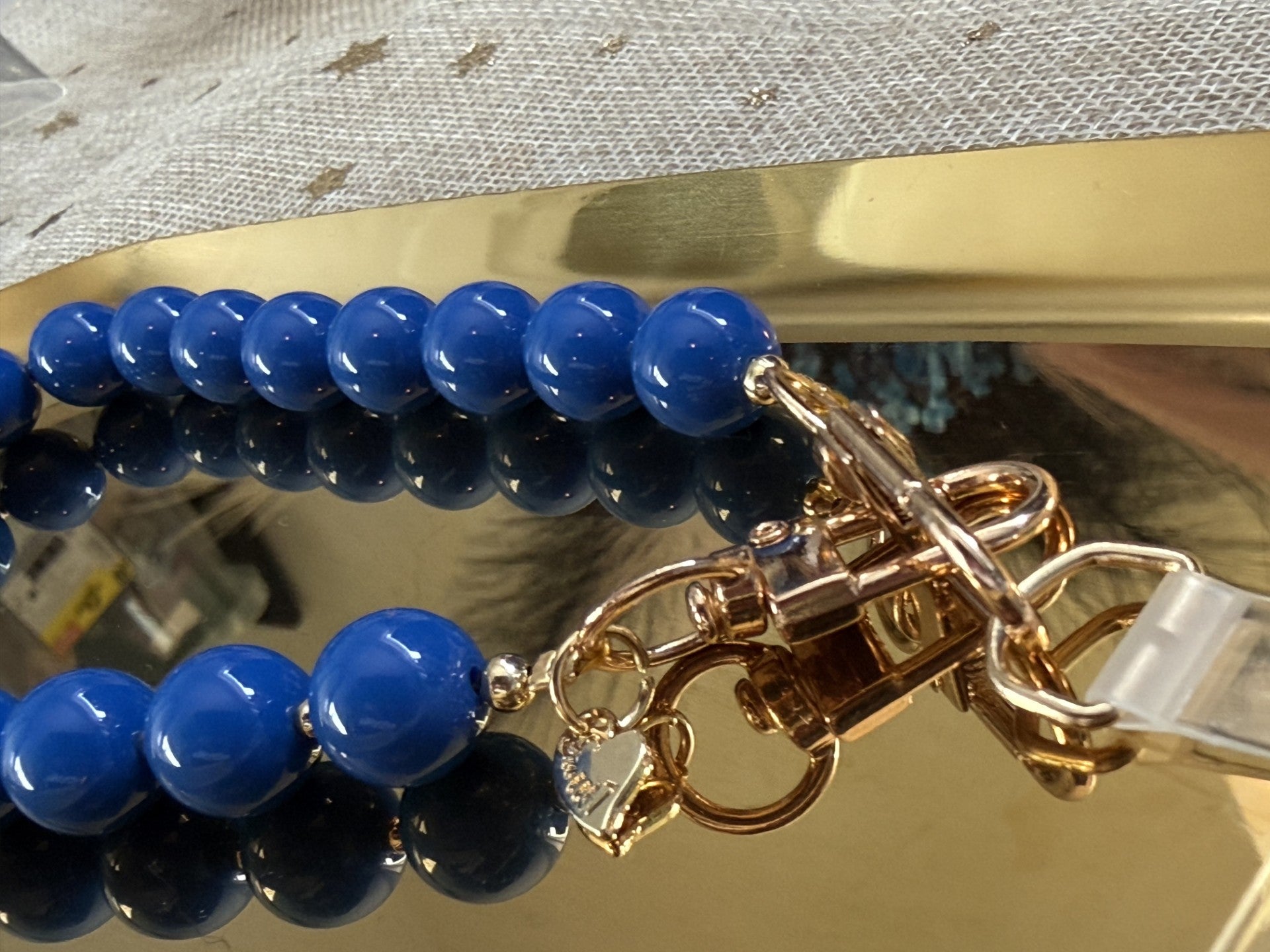 Close up van een blauwe telefoonkoord met gouden details op een goudkleurige schaal.