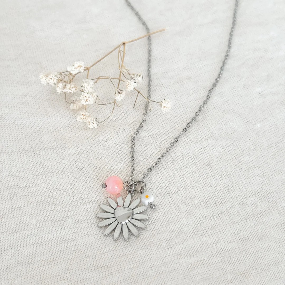 Detailopname van de zilveren RVS damesketting met zonnebloem hanger, roze-oranje Perzisch Jade en wit bloemetje
