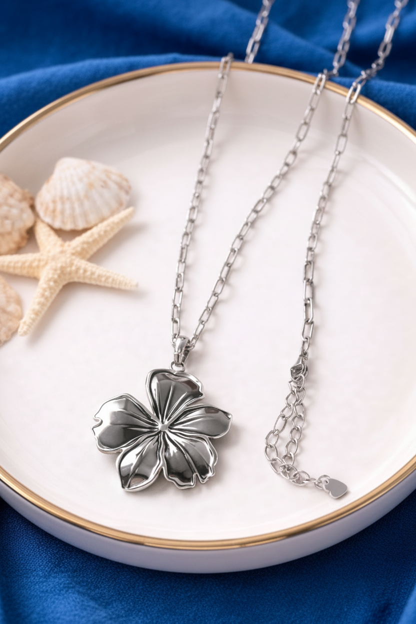 “Gouden ketting met bloem hanger, elegant dames sieraad met luxe en verfijnde uitstraling”gepresenteerd op een schaal.