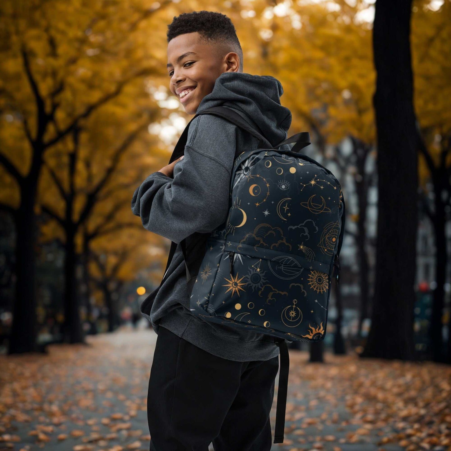 Boy wearing Mystic Moons and Stars Backpack with celestial design on city street in autumn
