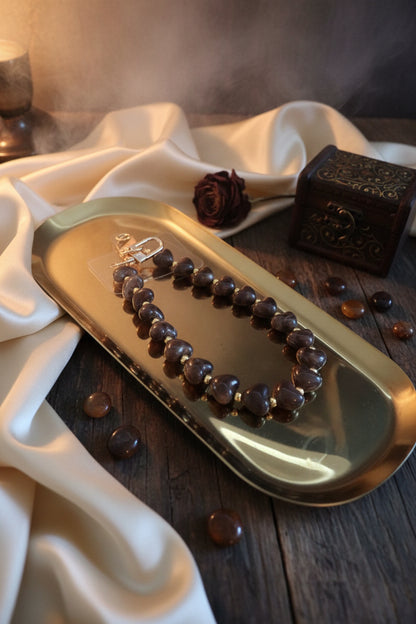 Glow Mystic in Style donkerbruin gemarmerd hartjes telefoonkoord van acryl in een lifestye setting.
