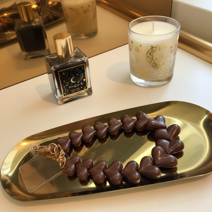 Bruin hartjes telefoonkoord van Glow Mystic in Style op een goudkleurige schaal met 2 lifestyle producten eromheen