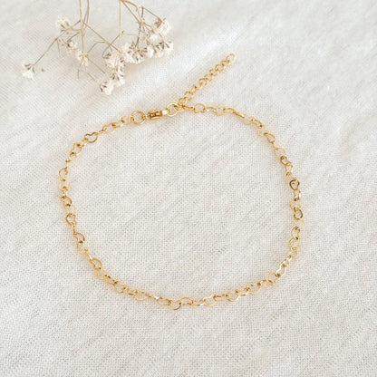 Detail van goudkleurige hartvormige schakels enkelbandje