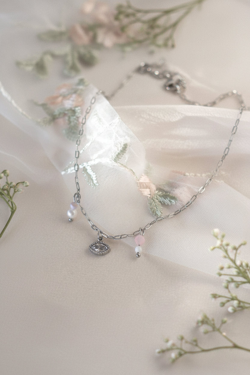 Stainless steel oog ketting met rozenkwarts en maansteen op wit satijn