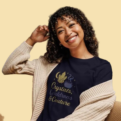 Woman wearing navy Crystals Cauldrons and Couture T Shirt with crystal and cauldron design, cozy beige cardigan indoors