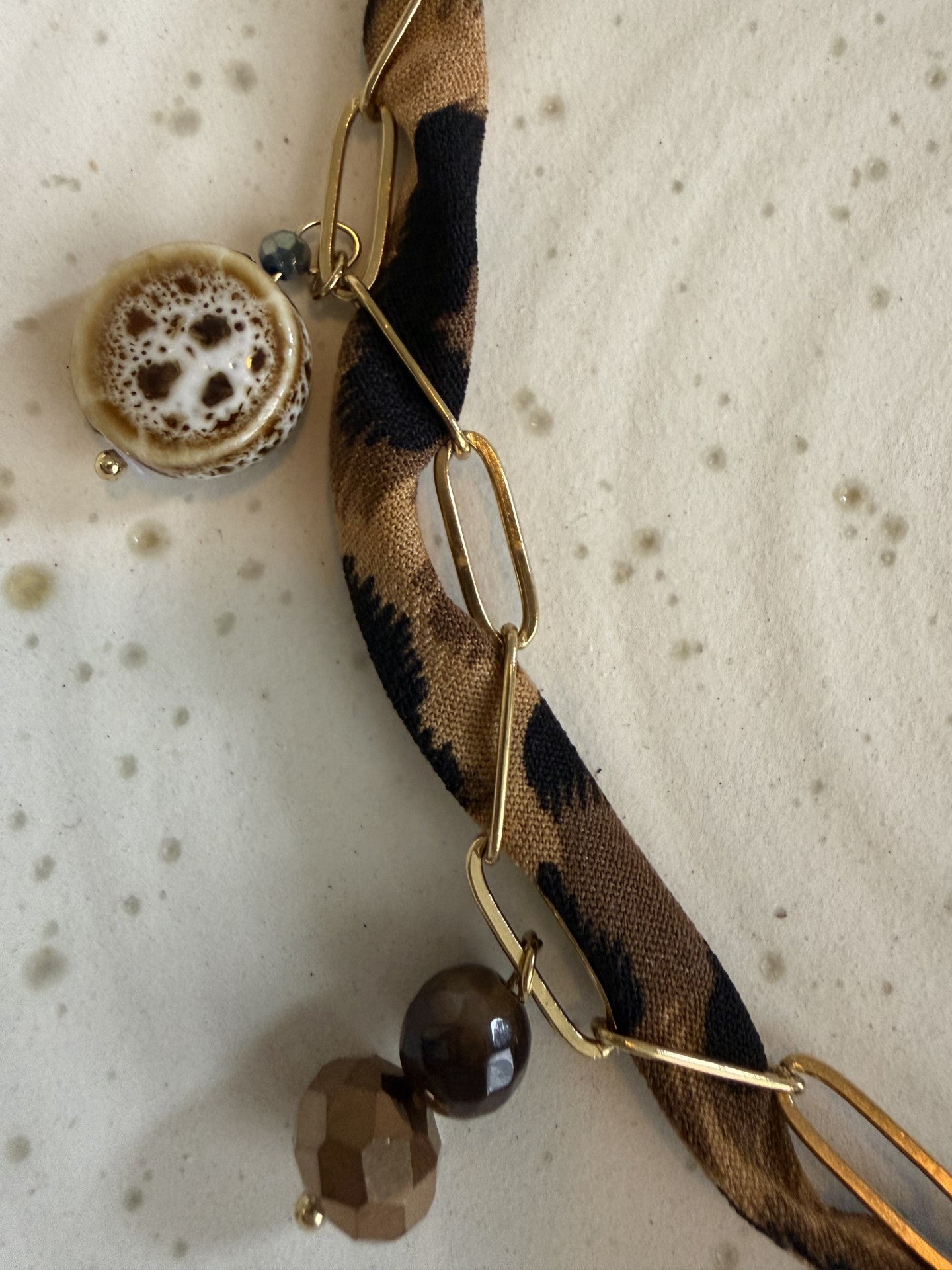 "Gedetailleerde close-up van de bedels aan de panterprint choker