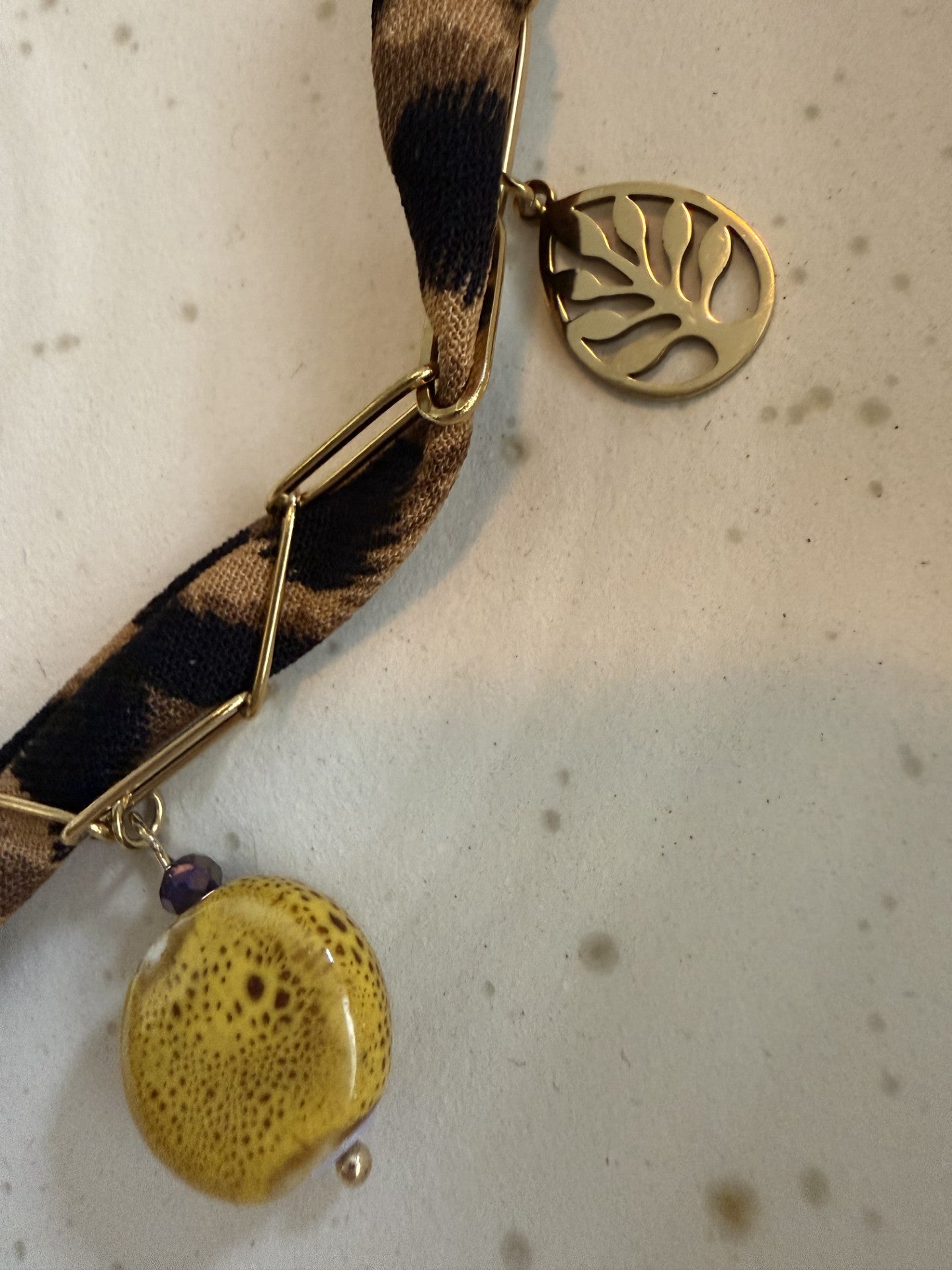 "Gedetailleerde close-up van de bedels aan de panterprint choker