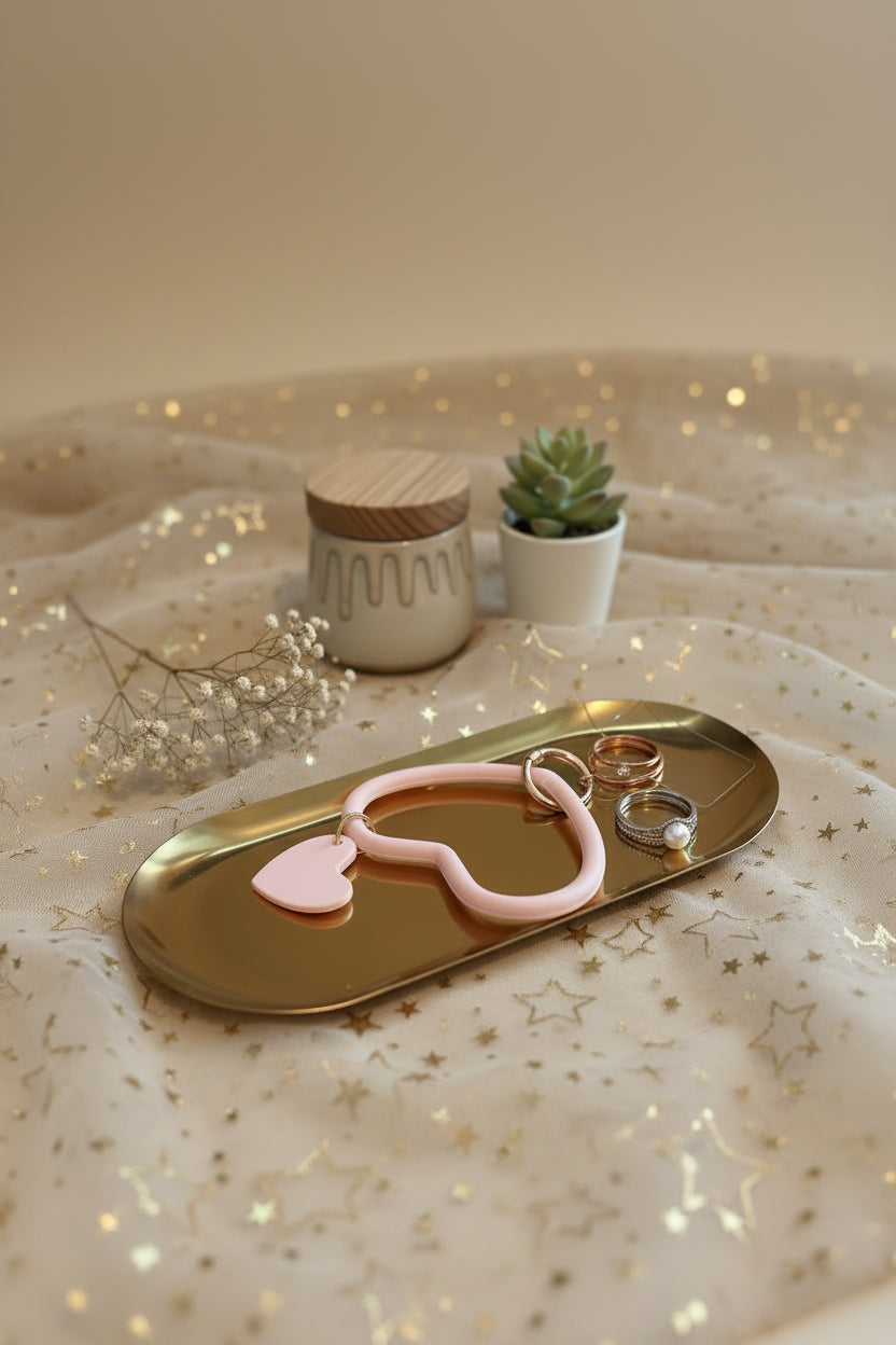 Overzichtsfoto van het Glow Mystic in Style lichtroze hartjes telefoonaccessoire met bedel op gouden tray