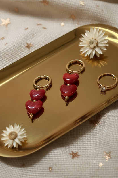 Glow Mystic in Style gouden stainless steel oorbellen met dubbele karmozijnrode hartjes op gouden schaal