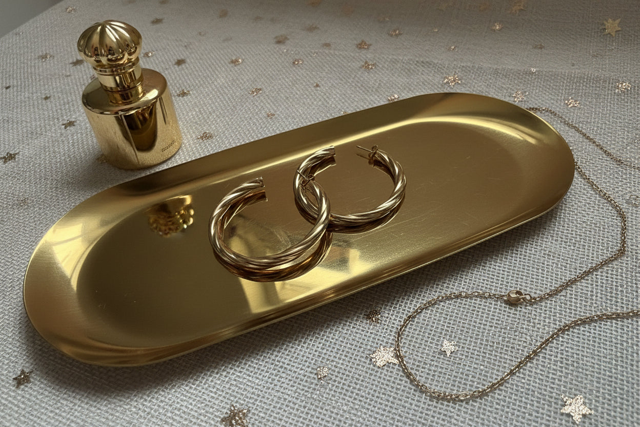 Close up van Glow Mystic in Style goudkleurige hoop oorbellen op een gouden tray