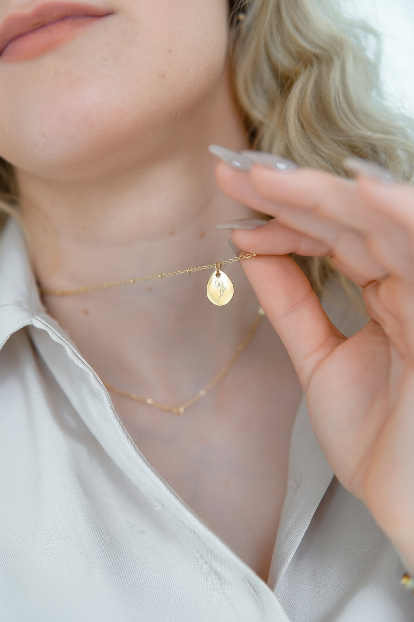Minimalistische geboortebloem ketting als persoonlijk cadeau gedragen om de hals