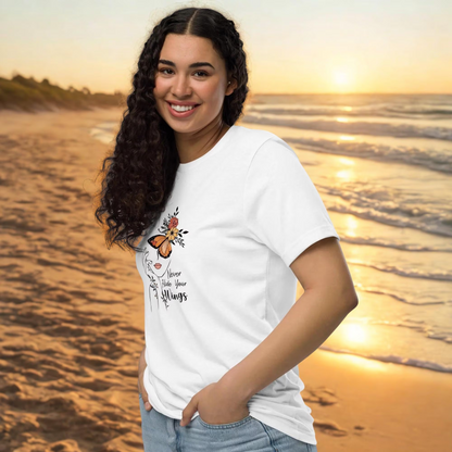 Woman wearing white Butterfly Graphic Organic Cotton T Shirt with butterfly and floral design at beach during sunset