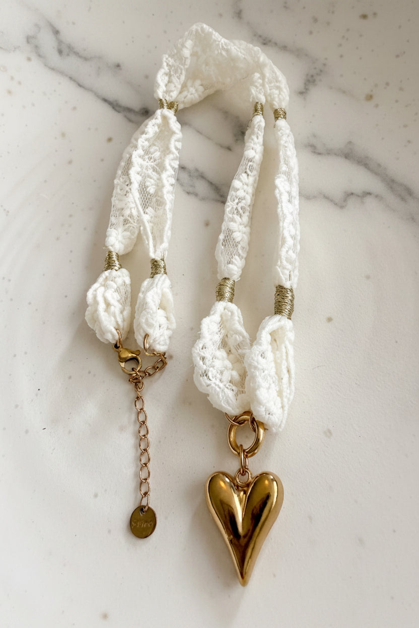 Gedetailleerde studio lay-flat opname van de Glow Mystic kanten choker, die de textuur en de RVS hanger duidelijk laat zien gepresenteerd op een marmeren plaat.