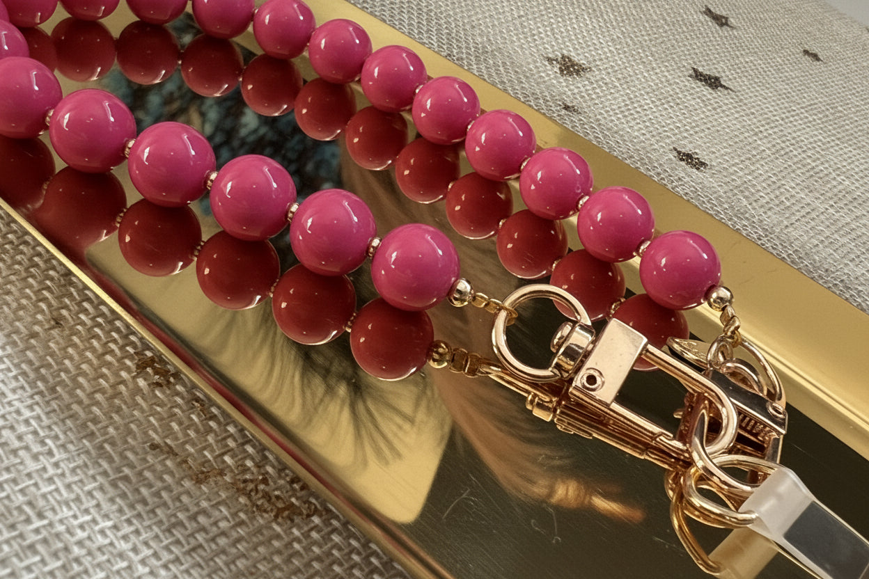 Close up van de Glow Mystic in Style fuchsia roze telefoonkoord op een goudkleurige schaal.