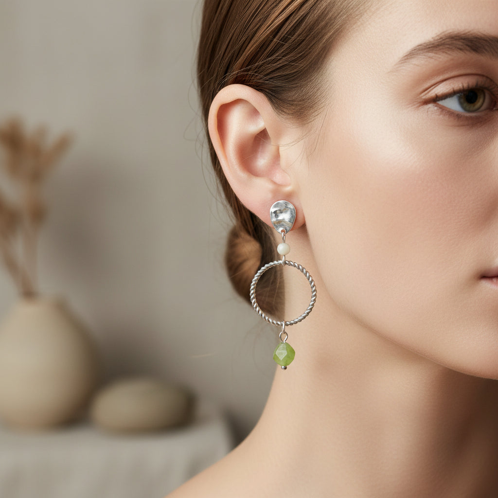 Statement oorbellen met peridot en maansteen van Saint Clairmont in oor gedragen