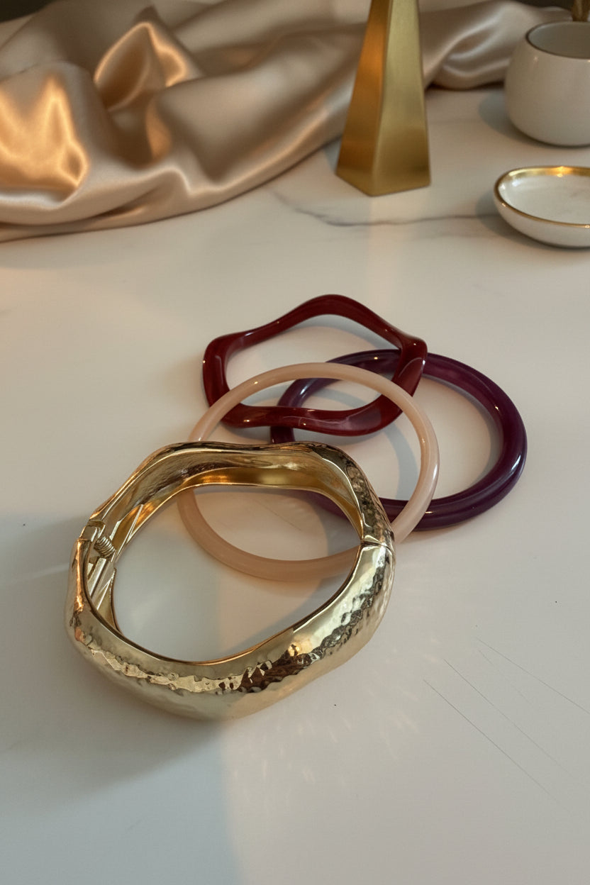 Glow Mystic in Style goudkleurige scharnier bangle armband met golvend design gepresenteerd met een lifestyle setting.