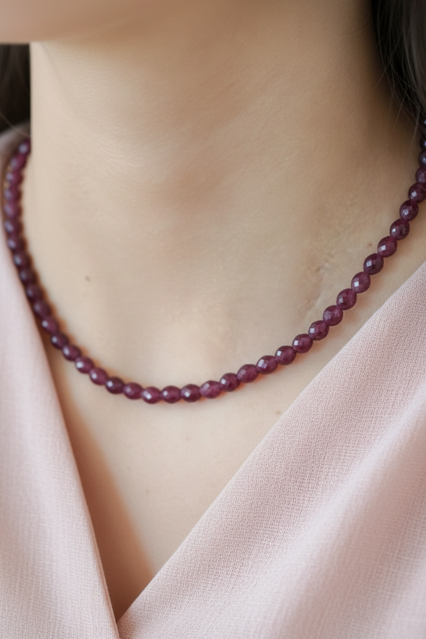 Close-up van bordeauxrode granaat edelsteen ketting gedragen om de hals